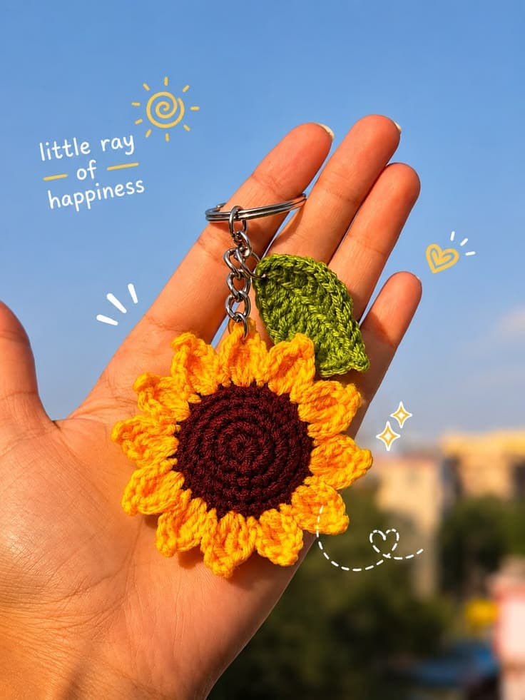 Handmade crochet sunflower keychain held in a hand