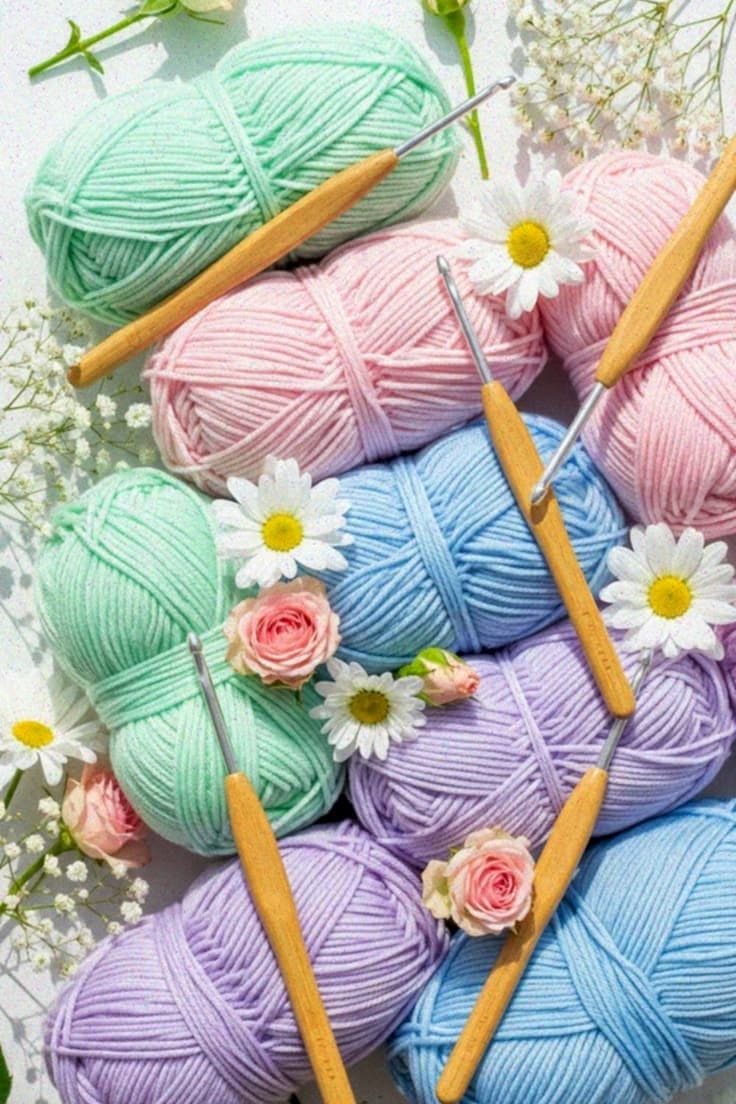 Pastel cotton yarn, wooden crochet hooks and daisies
